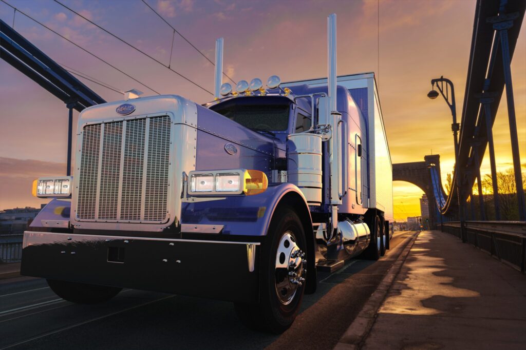 Truck with a semitrailer driving across the bridge at sunrise