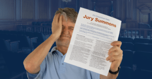 Upset and stressed man holding a paper that reads "jury summons"