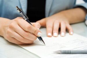 person writing on a document